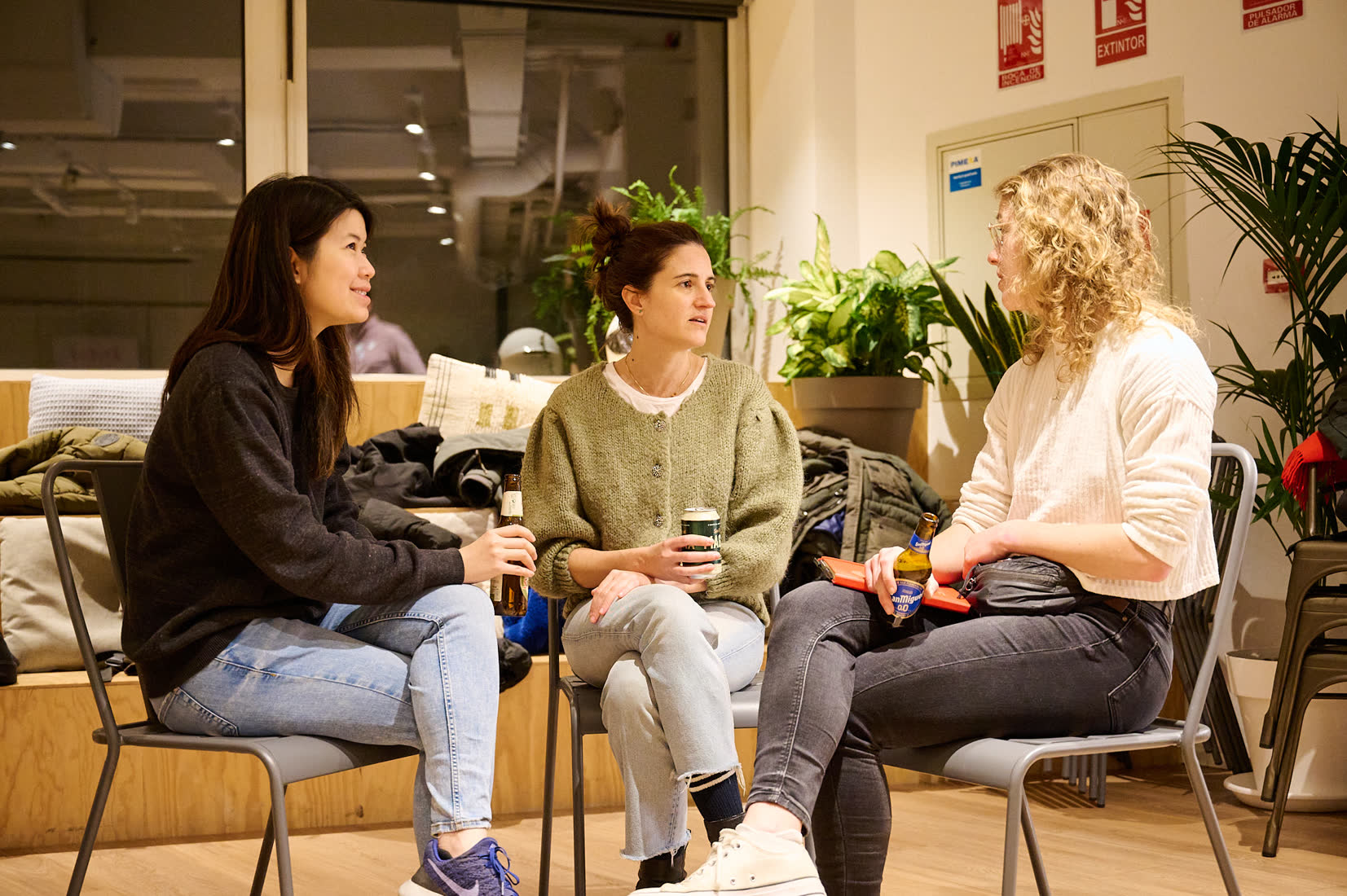 Three members chatting on chairs at a meetup